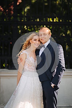 Happy young couple in their wedding day spend time in park. Green background