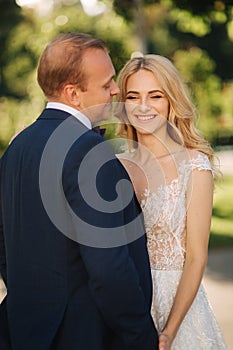 Happy young couple in their wedding day spend time in park. Green background