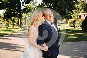 Happy young couple in their wedding day spend time in park. Green background