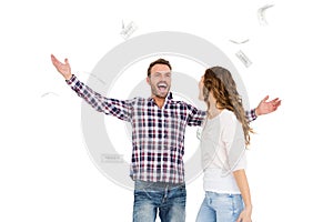 Happy young couple throwing currency notes in air