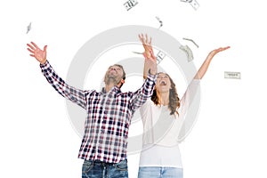 Happy young couple throwing currency notes in air photo