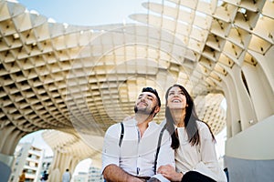 Happy young couple tourists visiting Setas de Seville aka Metropol Parasol, site seeing attractions.Vacation in south of Spain