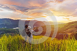 Happy young couple traveler relaxing and looking at the beautiful sunrise on the top of mountains