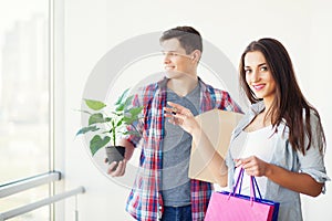 Happy young couple unpacking or packing boxes and moving into a