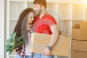 Happy young couple unpacking or packing boxes and moving into a