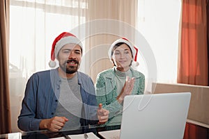 happy young couple use or watch something on laptop pc for christmas