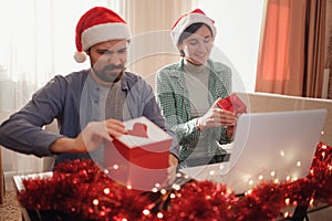 happy young couple use or watch something on laptop pc for christmas