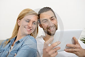 Happy young couple using digital tablet