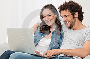 Happy Young Couple Using Laptop