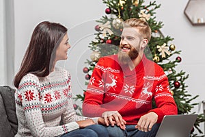 Couple using laptop at christmastime