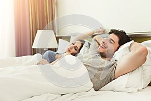 Happy young couple waking up in the morning on bed