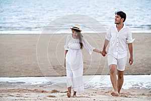 Happy young couple walk on the beach on honeymoon.