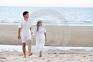 Happy young couple walk on the beach on honeymoon.