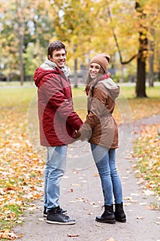 Happy young couple walking in autumn park