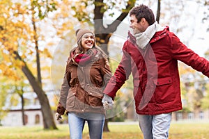 Happy young couple walking in autumn park