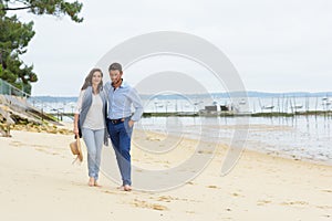 Happy young couple walking on beach