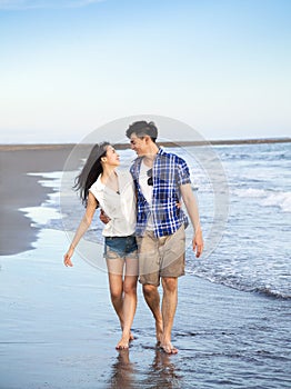 Happy young couple walking on the beach
