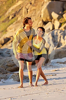 Happy young couple walking on beach together