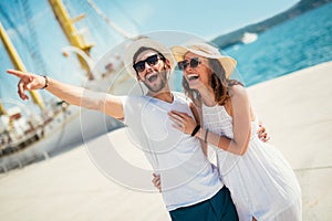 Happy young couple walking by the harbor of a touristic sea resort