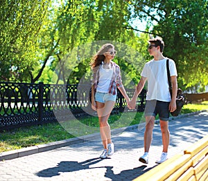 Happy young couple walking in summer park