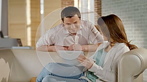 Happy young couple watching family photos on tablet PC, pleasant memories