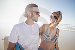 Happy young couple wearing sunglasses at beach