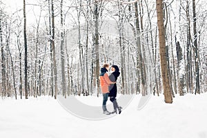 Happy Young Couple in Winter Park having fun. Family Outdoors
