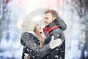 Happy Young Couple in Winter Park laughing and having fun. Family Outdoors.