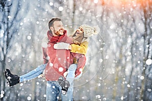 Happy Young Couple in Winter Park laughing and having fun. Family Outdoors.