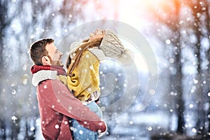 Happy Young Couple in Winter Park laughing and having fun. Family Outdoors.