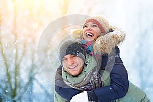 Happy Young Couple in Winter Park laughing and having fun. Family Outdoors.