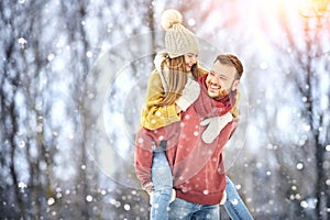 Happy Young Couple in Winter Park laughing and having fun. Family Outdoors. photo