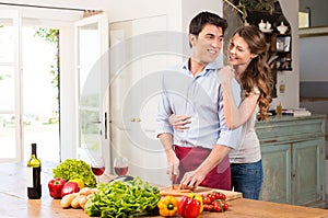 Happy Young Couple Working In Kitchen