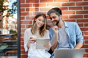 Happy young couple working studying on laptop and digital devices. Business education people concept