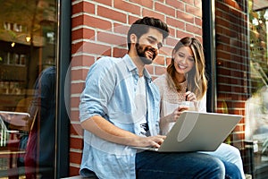 Happy young couple working studying on laptop and digital devices. Business education people concept