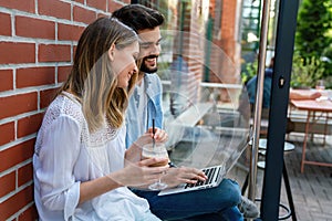 Happy young couple working studying on laptop and digital devices. Business education people concept