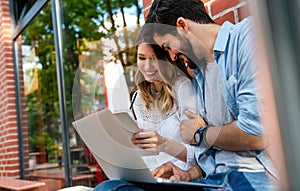 Happy young couple working studying on laptop and digital devices. Business education people concept