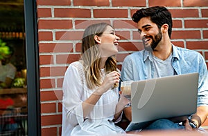 Happy young couple working studying on laptop and digital devices. Business education people concept