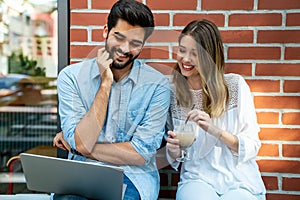 Happy young couple working studying on laptop and digital devices. Business education people concept