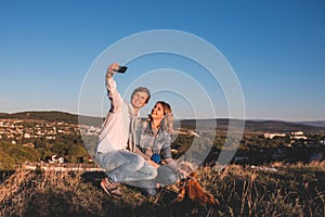 Happy young cute couple making selfie outdoors