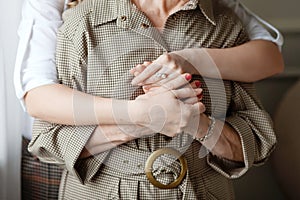 Happy young daughter hugs her mother with love. Young woman and middle-aged mum have fun at home together. Close up image