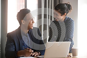 Happy young diverse employees discussing project agreement