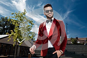 Happy young elegant man walking in red velvet tuxedo