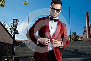 Happy young elegant man wearing red velvet tuxedo