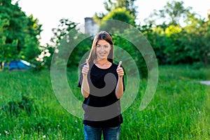 A happy young European girl. In the summer in park on vacation. Shows hand gesture two fingers up. A happy endorsement