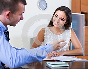 Young woman and man with financial documents in agency