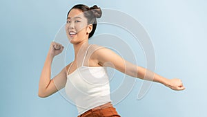 Happy young excited shocked woman posing isolated over blue wall background looking aside