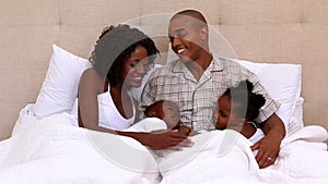 Happy young family in bed together