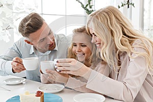 happy young family clinking coffee cups