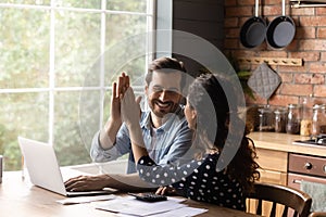 Happy young family couple celebrating successful investment.